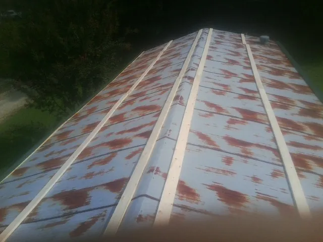 Rusted metal roof panels with new wood purlins before replacement — Storm Damage Roof Repair in Kyle by Roofing Brothers