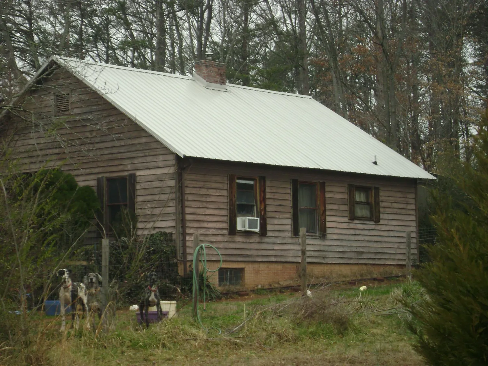 White metal roof on an old wood sided farmhouse, from a Metal Roof Installation job in Kyle
